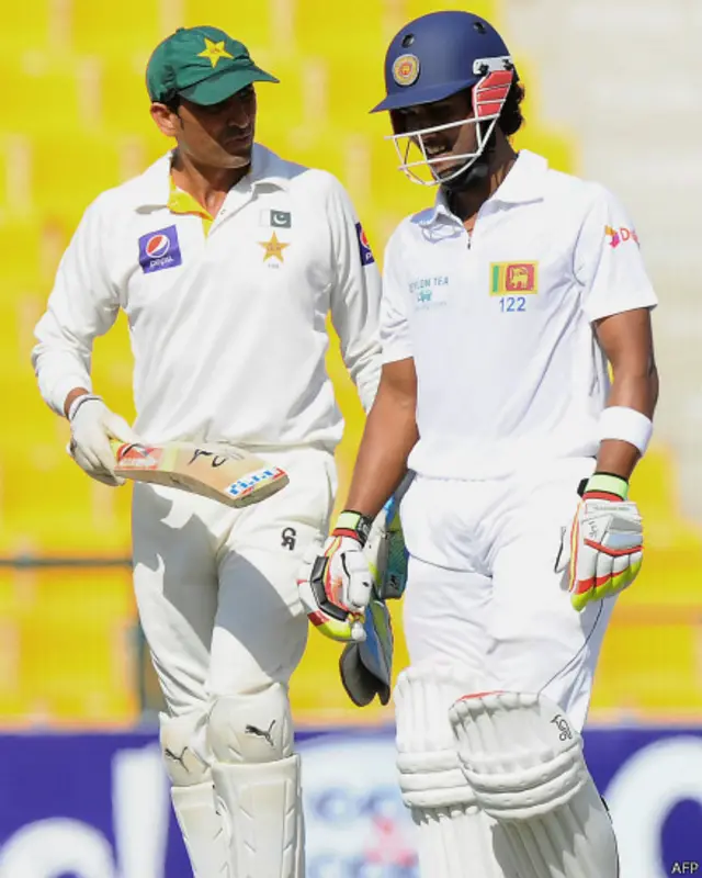 یونس خان سری لنکا کے بیٹسمین چندی مل سے بات چیت کر رہے ہیں۔ پاکستانی وکٹ کیپر عدنان اکمل کی انگلی پر چوٹ لگنے کے بعد یونس خان وکٹ کیپنگ کر رہے ہیں۔