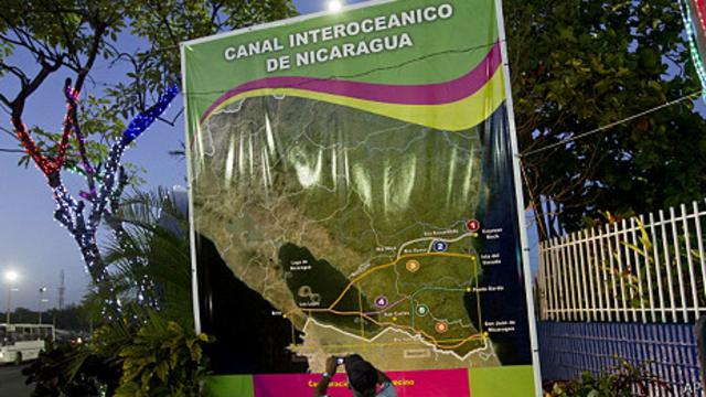 尼加拉瓜首都馬拉瓜一名工人在大運河宣傳計劃海報前拍照（4/12/2013）