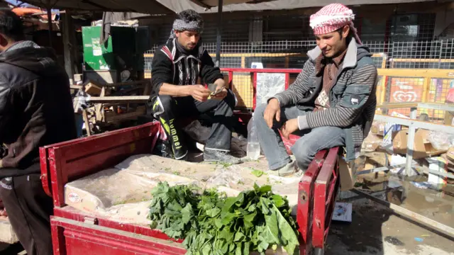مزارعان يقومان ببيع منتجاتهما في احد اسواق الفلوجة في الثامن من كانون الثاني.