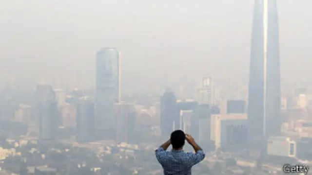 Un hombre fotografía el humo en Santiago