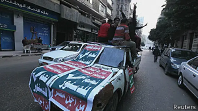 Hombres en una camioneta con campaña electoral