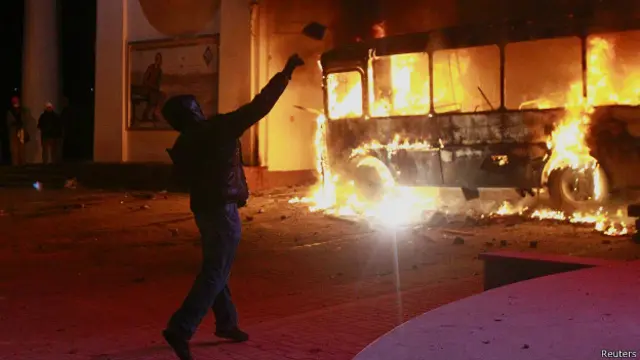 Протестующий на фоне горящего автобуса в Киеве