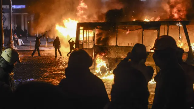 Las llamas de uno de los cinco autobuses de la policía incendiados por los manifestantes dieron un aspecto dramático a un día de enfrentamientos entre la policía y manifestantes en el centro de Kiev.