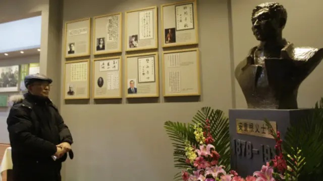 أحد زائري المتحف من الصينيين يتفقد المعروضات فيه.