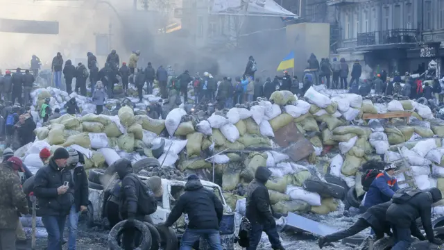 معترضان در مقابل پلیس ضدشورش موانعی ایجاد کرده اند.