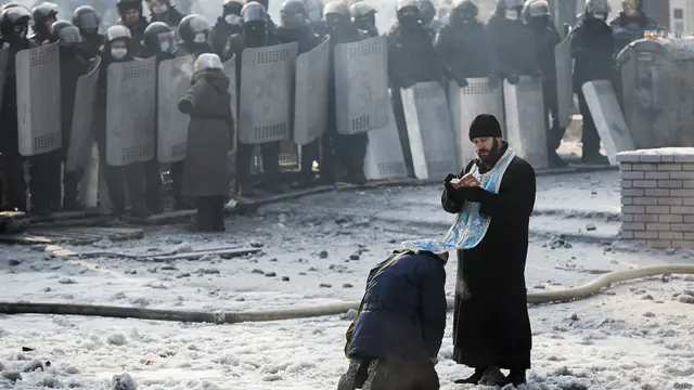 Un sacerdote y policías a lo lejos