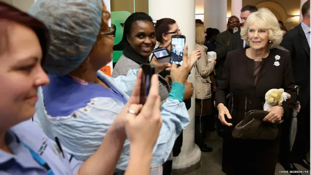  लंदन के किंग्स कॉलेज अस्पताल के कर्मचारी ब्रिटेन के युवराज प्रिंस चार्ल्स की पत्नी कैमिला की तस्वीर लेते हुए .