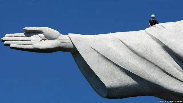 एक कारीगर रियो डी जेनरो में 'क्राइस्ट द रिडीमर' की मूर्ती के ऊपर हुए नुकसान का जायज़ा लेते हुए. एक पहाड़ की चोटी पर बनी इस लाजवाब मूर्ती का एक अंगूठा बिजली गिरने की वजह क्षतिग्रस्त हो गया था.