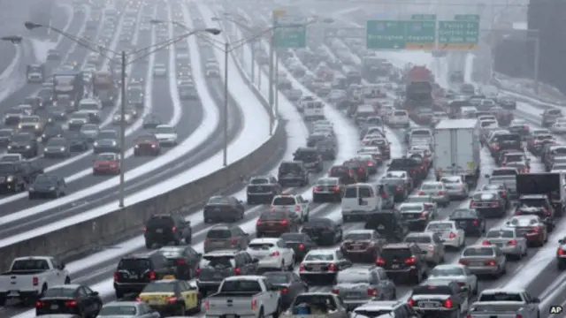 تقطع السبل بالآلاف الأمريكيين جراء العاصفة الثلجية التي أدت أيضاً إلى إصابة حركة المرور بالشلل التام