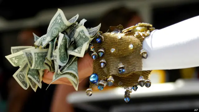 Artista sostiene puñado de dólares