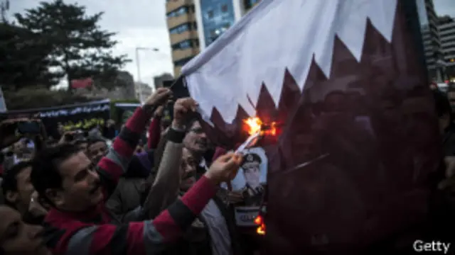 Supporters of Egypt's military chief Abdel Fattah al-Sisi set fire to a Qatari national flag during a demonstration outside the Qatari embassy in Cairo on November 30