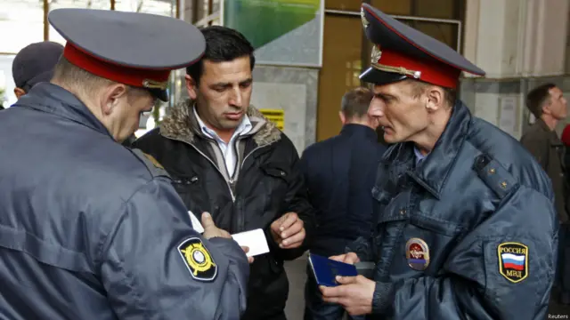 عناصر أمن في محطة قطار سوتشي يقومون بتفقد جوازات سفر الزوار، ضمن مجموعة من الإجراءات الأمنية المشددة التي تتخدها الحكومة الروسية لتأمين الأولمبياد. 