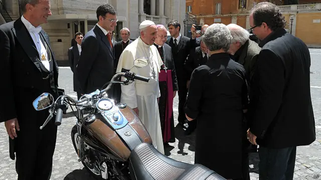 पोप को उपहार में मोटरसाइकिल देते अधिकारी