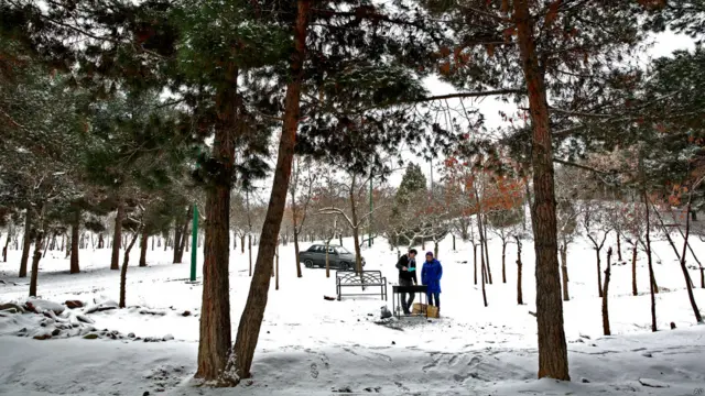 Dua pasangan menyalakan api di Teheran, Iran.