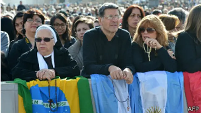 Feligreses con banderas en la plaza San Pedro, el Vaticano