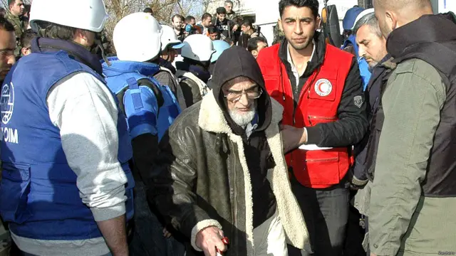 रे़डक्रॉस और संयुक्त राष्ट्र कर्मचारी के साथ एक बुजुर्ग