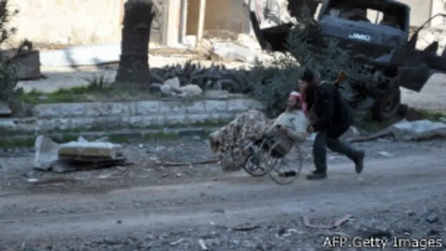 یک امدادگر در حال نجات یکی از اهالی حمص 