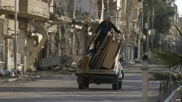 homem em cima de caminhão na Síria