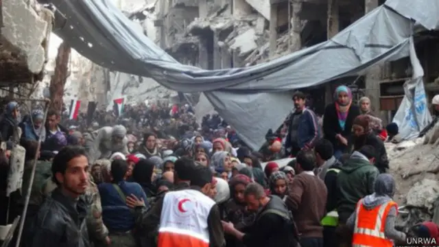 تزاحم آلاف الفلسطينيين قرب مدخل المخيم للحصول على المساعدات الغذائية.