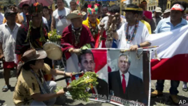 Chamán haciendo ceremonia frente a fotos de presidentes Piñera y Humala
