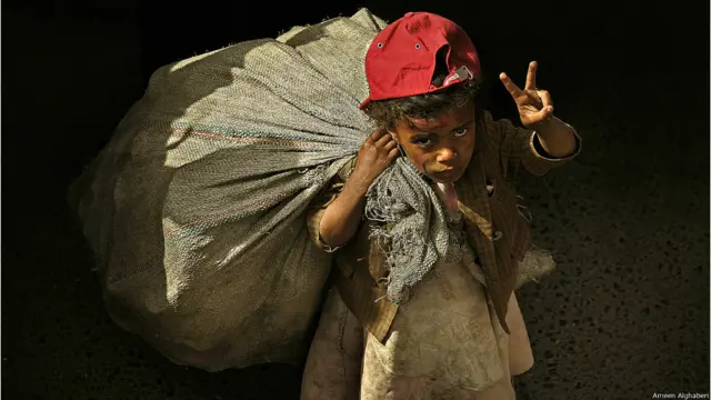 فتاة تجمع العلب البلاستيكية الفارغة لتحصل على قوت يومها حضرت لميدان التغيير رافعة بيدها علامة النصر تعبيراً عن تأييدها للشباب المعتصمين في ميدان التغيير. امين الغابري 2011