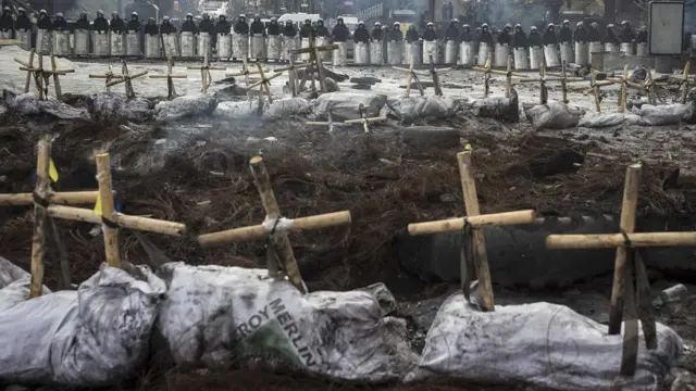 यूक्रेन में महीनों से सरकार विरोध प्रदर्शनों के चलते अशांति का माहौल है. सरकार विरोधियों ने प्रदर्शनों के दौरान हुई झड़पों में मारे गए और गायब हुए लोगों की याद में इस तरह के क्रॉस खड़े किए हैं जिनके पीछे दंगा नियंत्रक पुलिस बल के जवान मुस्तैदी से खड़े हैं.