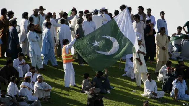 आबू धाबी के क्रिकेट स्टेडियम में पाकिस्तान का झंडा लहराते खेल प्रेमी