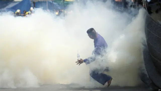 Demonstran di tengah serangan gas air mata. Foto: Wally Santana/AP