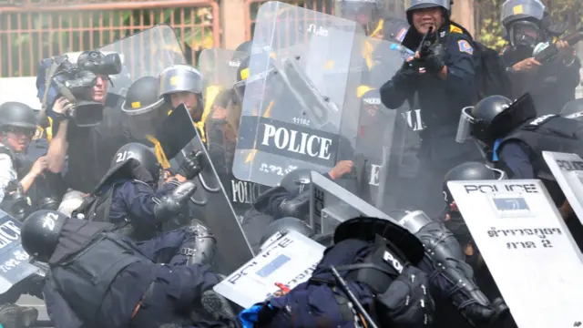 Seorang polisi anti huru-hara terjatuh saat bom meledak. Foto: Apichart Weerawong/AP