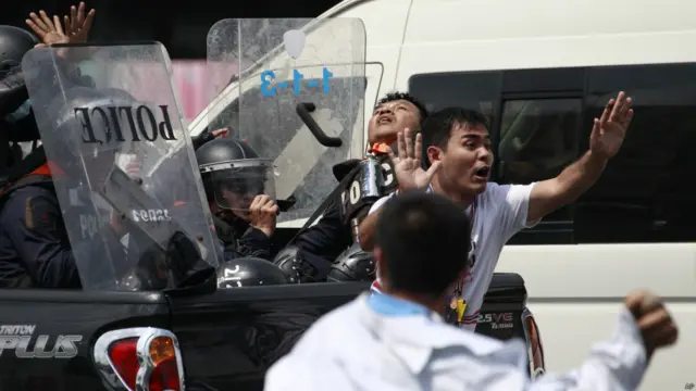 Seorang demonstran meminta rekannya menghentikan serangan. Foto: Wason Wanichakorn/AP