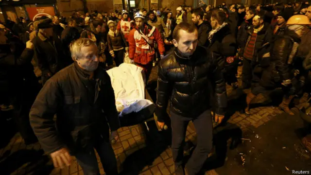 Opositores do governo transportam corpo de manifestante morto na Ucrânia (foto: Reuters)