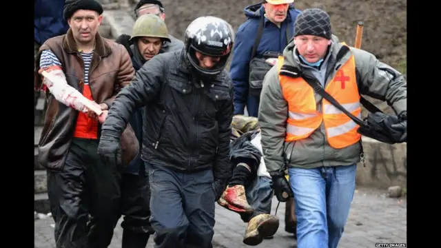 ہنگاموں میں اب تک سینکڑوں افراد زخمی ہو چکے ہیں۔ اس تصویر میں طبی امداد دینے والے رضاکار ایک زخمی کو آزادی چوک سے اٹھا کر لے جا رہے ہیں۔ 