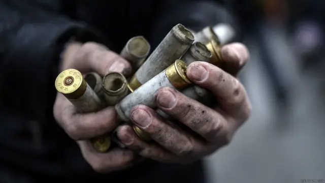 أحد المتظاهرين يعرض للمصورين أحد فوارغ الطلقات التي يقول إن الشرطة استخدمتها في مواجهة المحتجين.