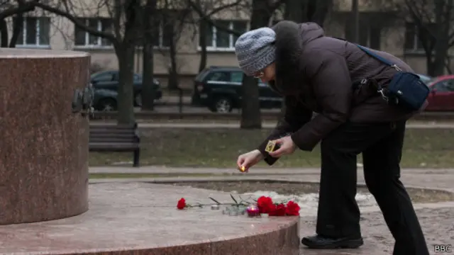 Женщина в Минске возлагает цветы у памятника Тараса Шевченко