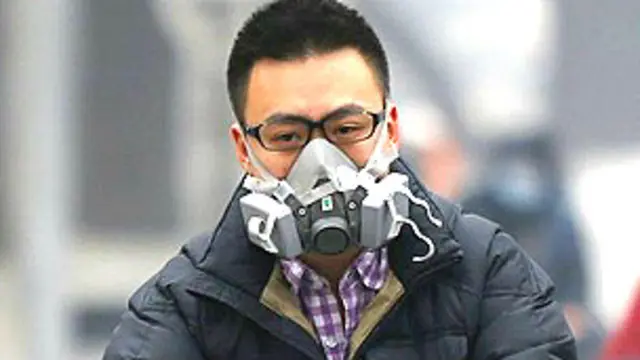 Joven con una máscara por la contaminación en Pekín