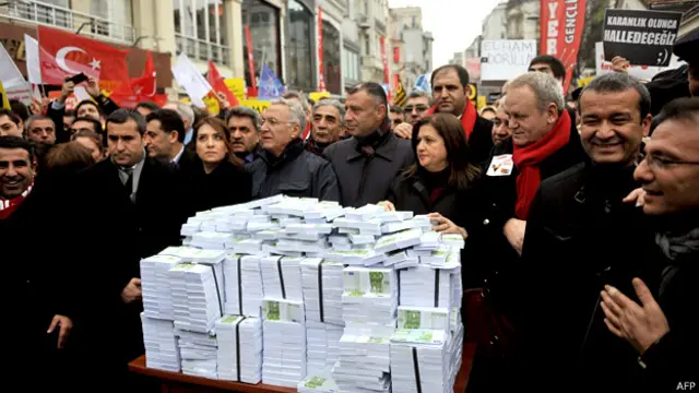 تظاهرات‌کنندگان در اعتراض به مکالمه‌ای که به آقای اردوغان نسبت می‌دهند ۳۰ میلیون یوروی جعلی را در خیابان استقلال استانبول به نمایش گذاشته‌اند