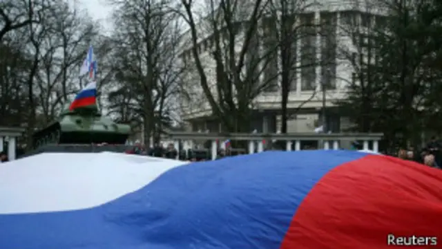 لاریونیان چې روسي بيرغونه رپوي د هغو وسله والو ملاتړ ته راغلي چې د پنجشنبې په ورځ يې ځايي پارلمان نيولى و.