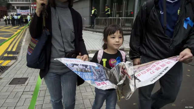 一名小女孩拿着用《明报》折成的纸鹤参加香港新闻界反暴力游行（2/3/2014）