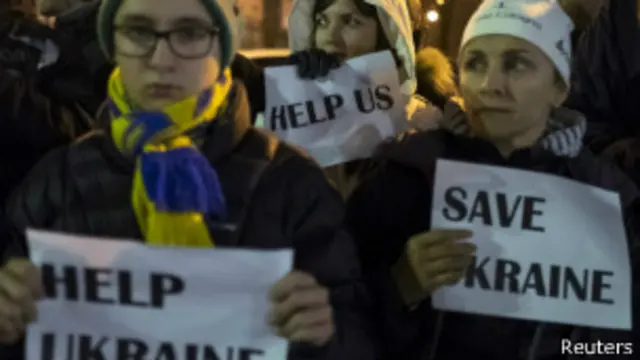 متظاهرون يحملون لافتات تقول "أنقذوا أوكرانيا"