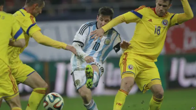 Lionel Messi berupaya melepaskan diri dari kepungan pemain Rumania.