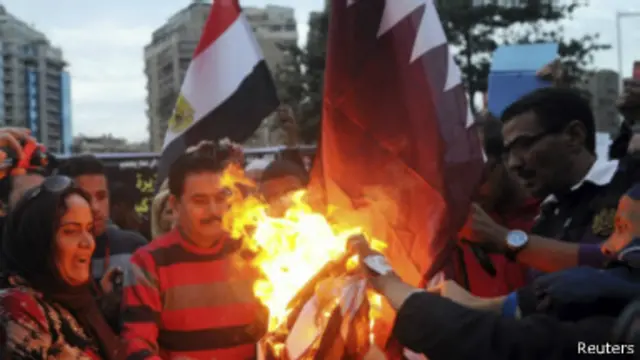 مصريون يحرقون علم قطر خارج سفارتها بالقاهرة 