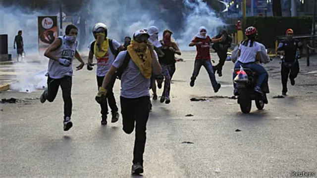 Manifestantes fogem do gás lacrimogêneo em Caracas (Reuters)