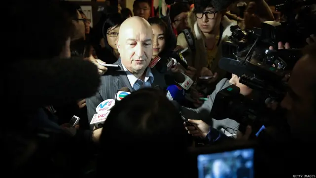 马航商务总监邓利维（Hugh Dunleavy，中）在北京丽都维景酒店内被记者包围（9/3/2014）