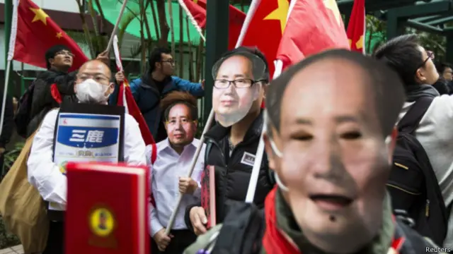 。抗议者高举国旗和毛主席画像,他们有的装扮成红卫兵,用广东话高唱国歌。