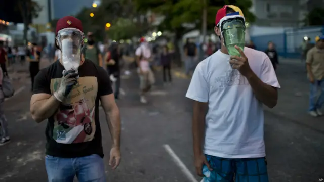 Manifestantes con botellas de plástico en la cara (Foto AP/Rodrigo Abd)