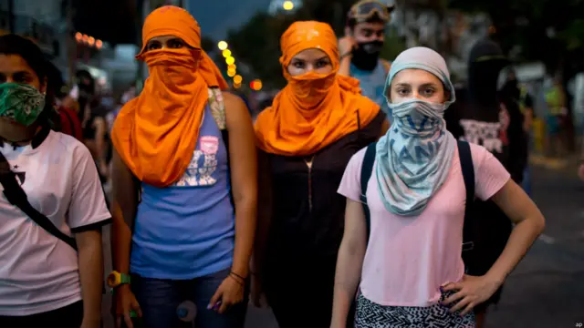 Jóvenes con el rostro cubierto en Caracas (Foto AP/Rodrigo Abd)