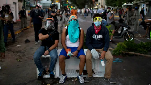 Manifestantes enmascarados descansan (Foto AP/Rodrigo Abd)