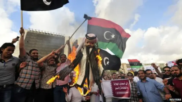 أشعل محتجون في بنغازي النار في دمية ترمز إلى أمير قطر السابق الشيخ حمد في 2013