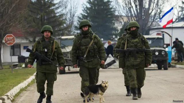 Militares supostamente russos caminham perto de base ucraniana (foto: Reuters)