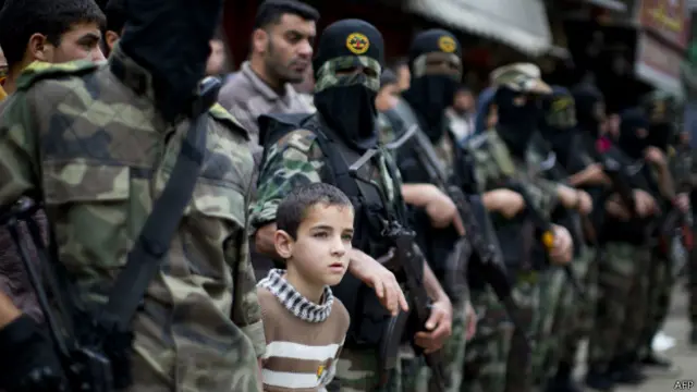 صبي فلسطيني يشارك مقاتلين من سرايا القدس في تشييع جثمان أحد قتلى الغارات الإسرائيلية.